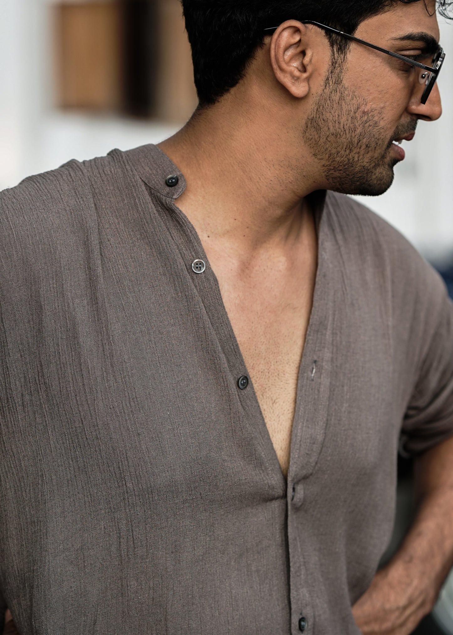 "Mod Maven Nude Brown Crushed Cotton Full Sleeve Shirt paired with Off-White Comfortable Fit Pants. Close up image of Male Model focused on the crushed cotton texture, wearing shades, showcasing a chic street style look."