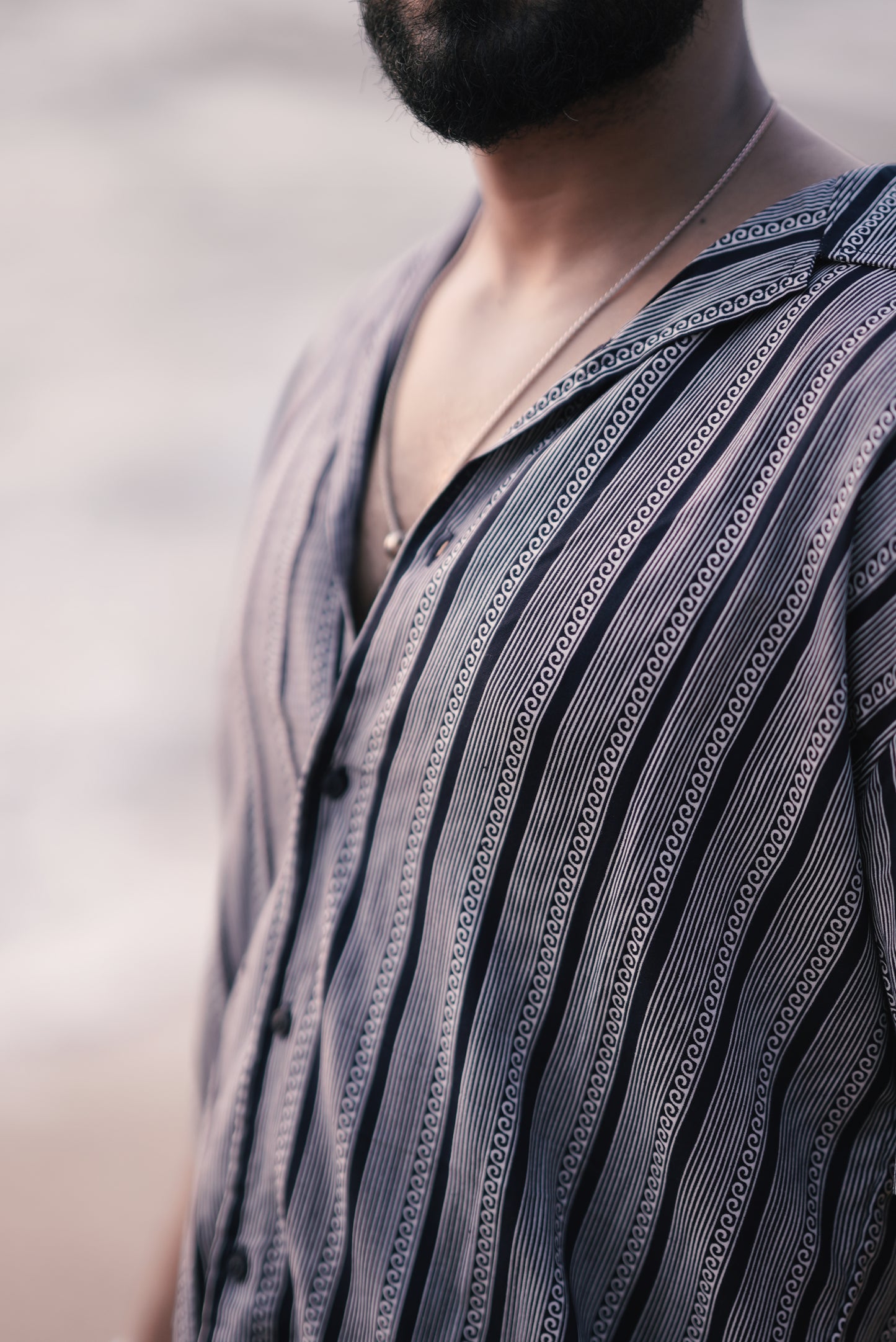 A close-up of the fabric from Mod Mavens' white and navy blue half-sleeve shirt, featuring detailed vertical wave and stripe patterns. The zoomed-in view emphasizes the shirt’s soft texture, intricate design, and premium fabric quality.