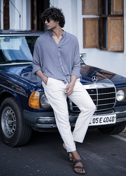 "Mod Maven Lilac Grey Crushed Cotton Full Sleeve Shirt paired with Off-White Comfortable Fit Pants. Model sitting on a vintage dark blue car, wearing shades, showcasing a chic street style look."