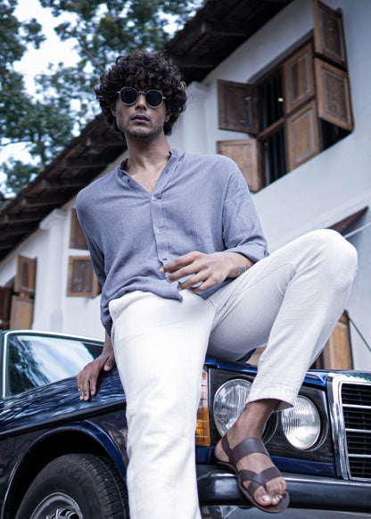 Mod Maven Lilac Grey Crushed Cotton Full Sleeve Shirt paired with Off-White Comfortable Fit Pants. Model sitting on a vintage dark blue car, wearing shades, showcasing a chic street style look.